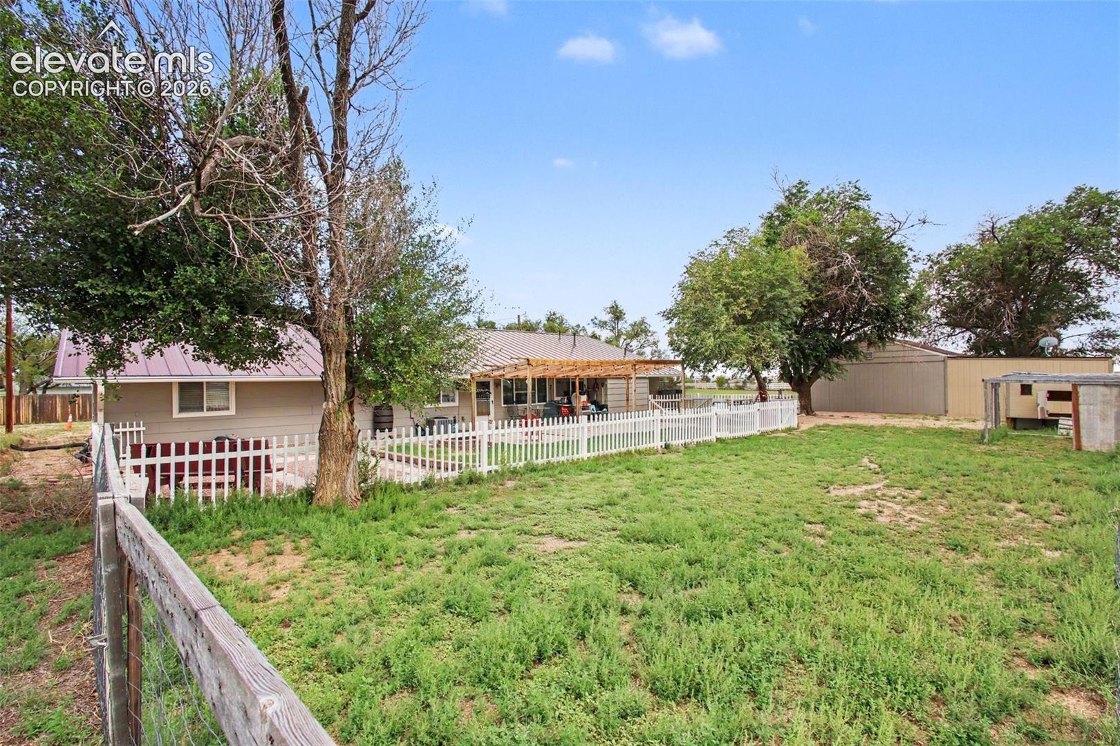Expansive fenced backyard offering privacy, plenty of room to enjoy the open space, and a charming chicken coop with abundant outdoor potential.