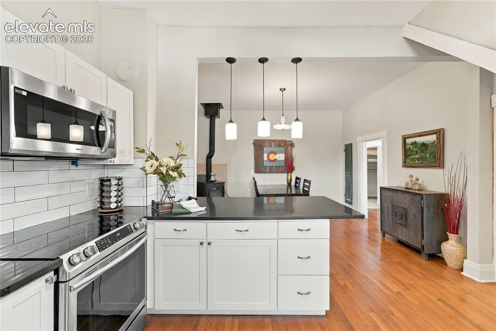 Primary kitchen on main, with updated appliances, solid surface counters and bar seating