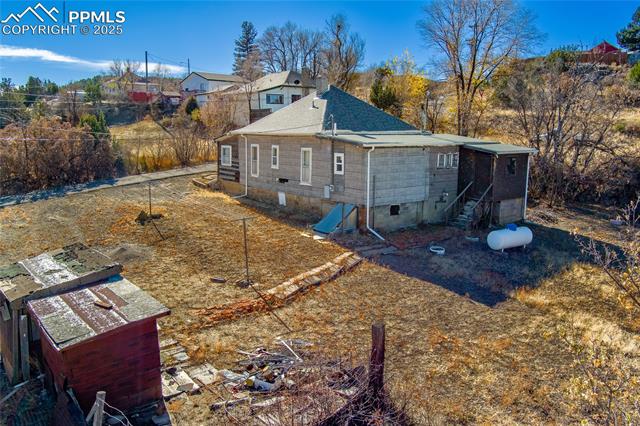 Rear view of house with crawl space and roof with shingles