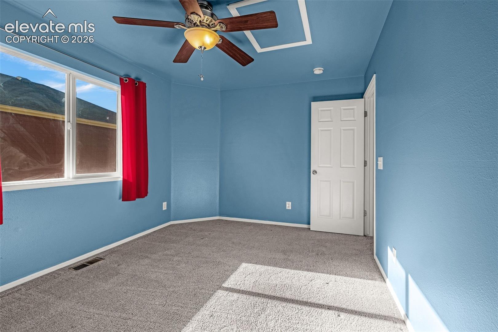 Interior room featuring wall-to-wall carpeting, a ceiling fan with integrated lighting, and a six-panel door