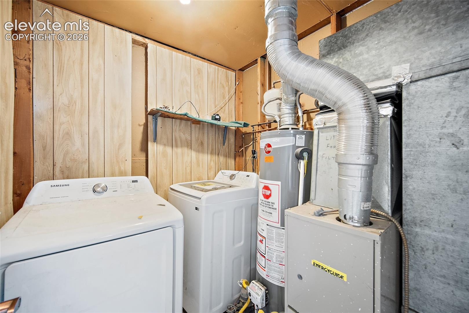 Wood paneling, built-in shelving, water heater, and furnace