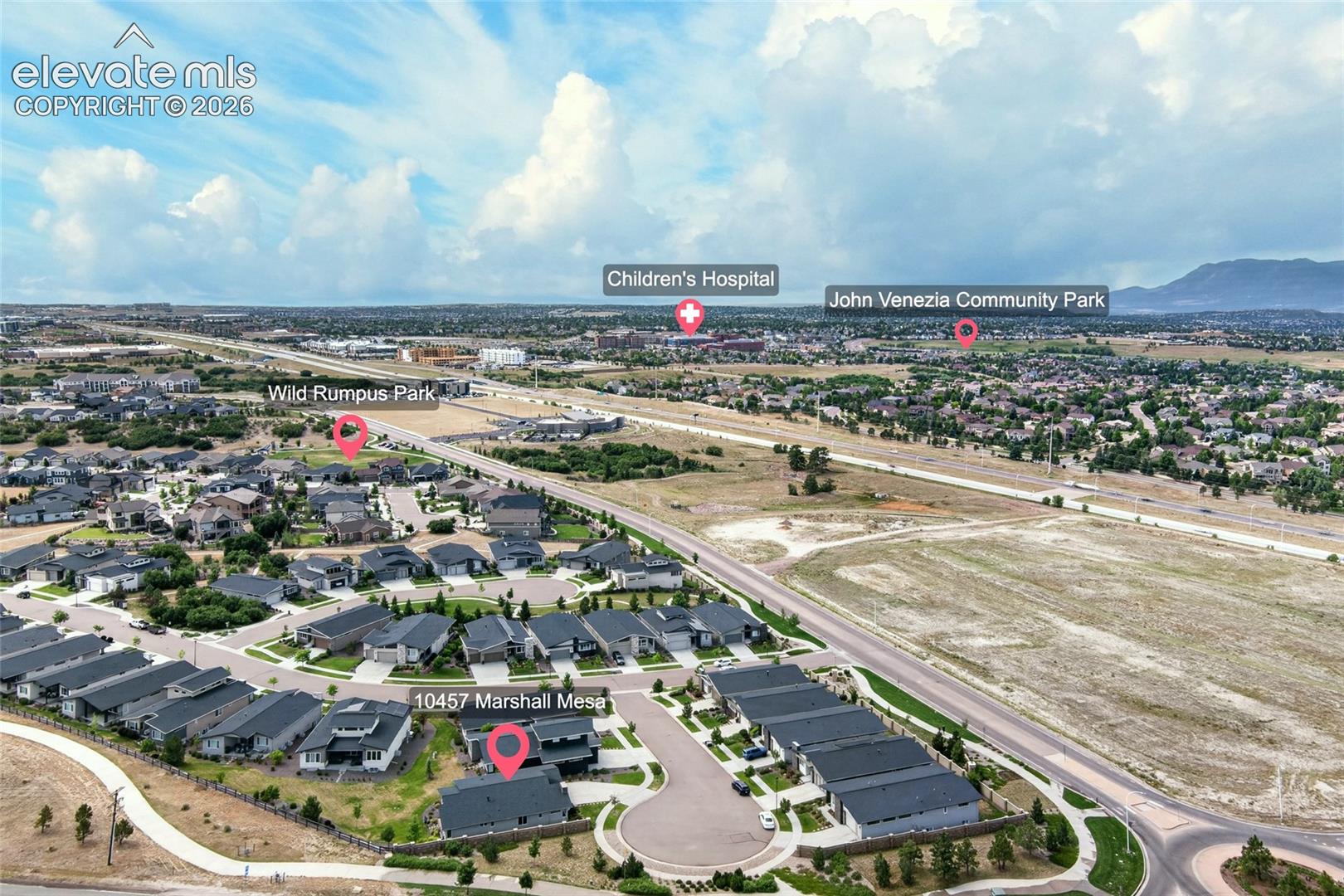 Aerial perspective showcasing a residential community with contemporary homes, curved street designs, and surrounding infrastructure