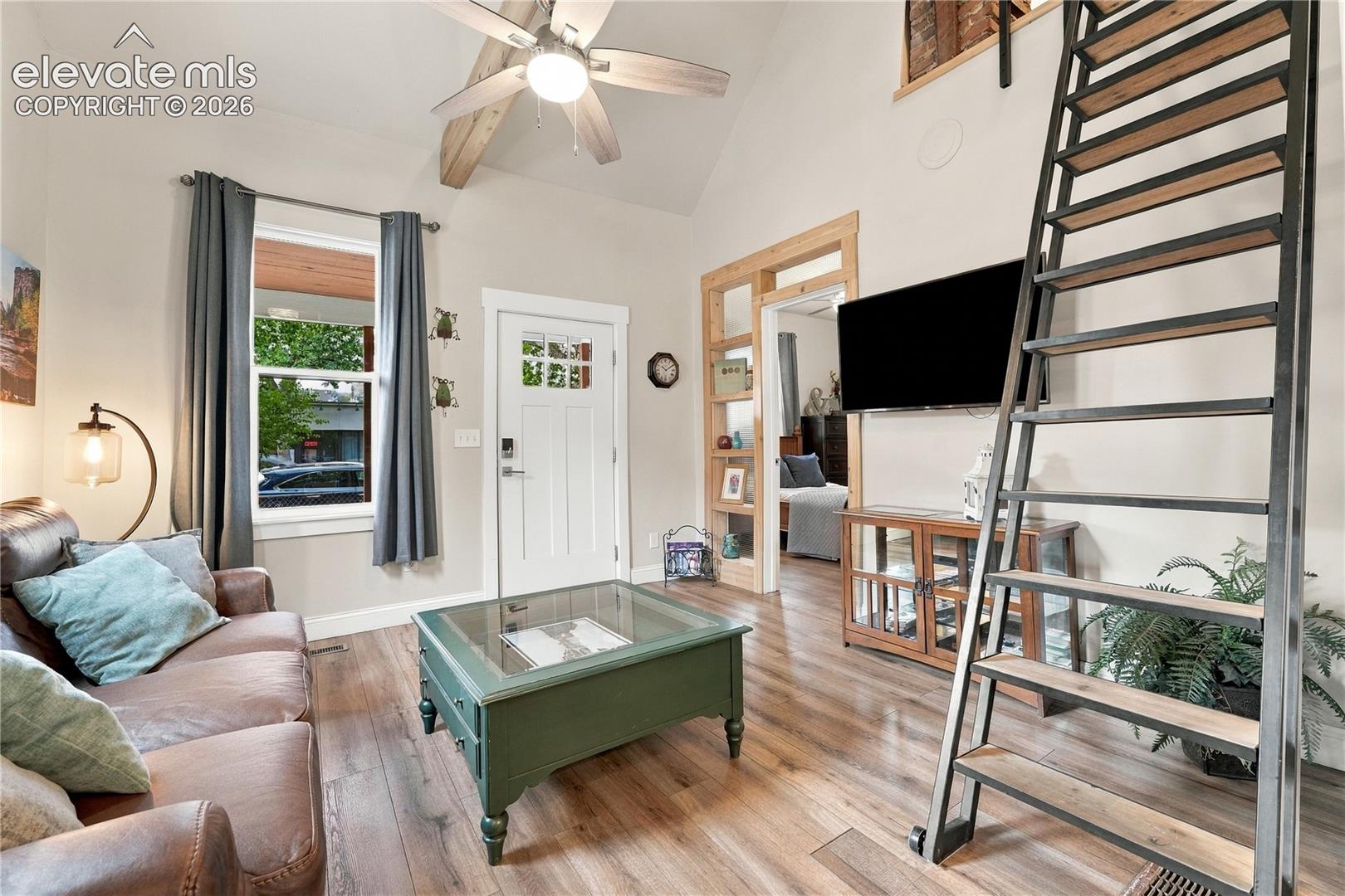 View from kitchen into living room and entry. Custom ladder leads to the loft. 
