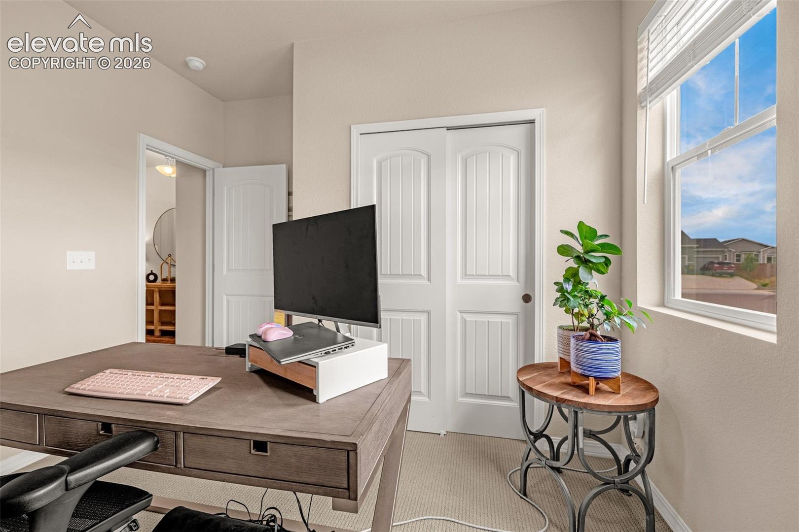 Recessed lighting, light-toned wall paint, a single window with blinds, and white sliding closet doors