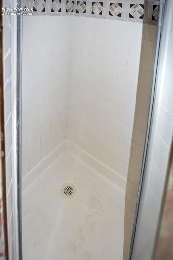 White tile shower with mosaic accent border
