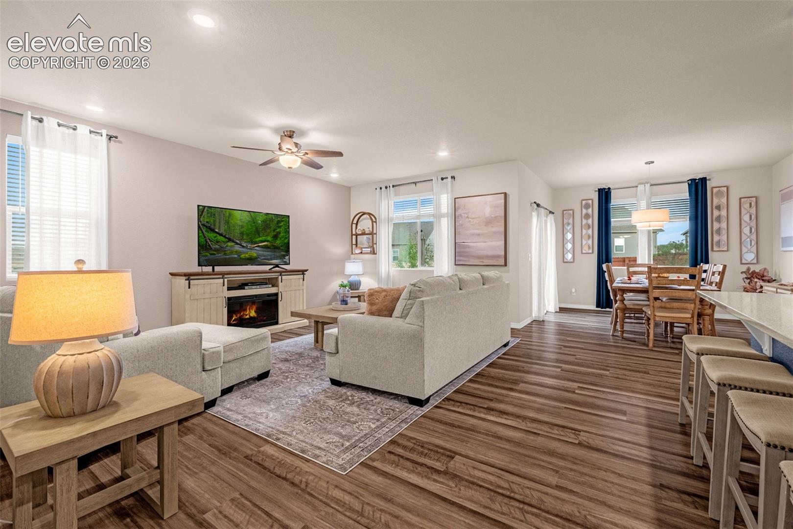 Open-concept living space featuring wood-finish flooring, recessed lighting, and a ceiling fan