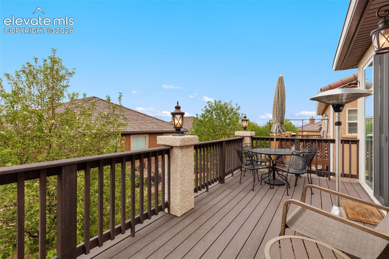 Looking east. Expansive outdoor deck featuring composite decking, dark wood railing, and integrated pillar lighting