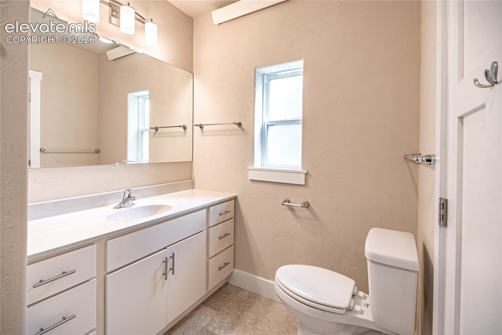 Full-width vanity with an integrated sink, polished chrome faucet, and ample storage cabinetry