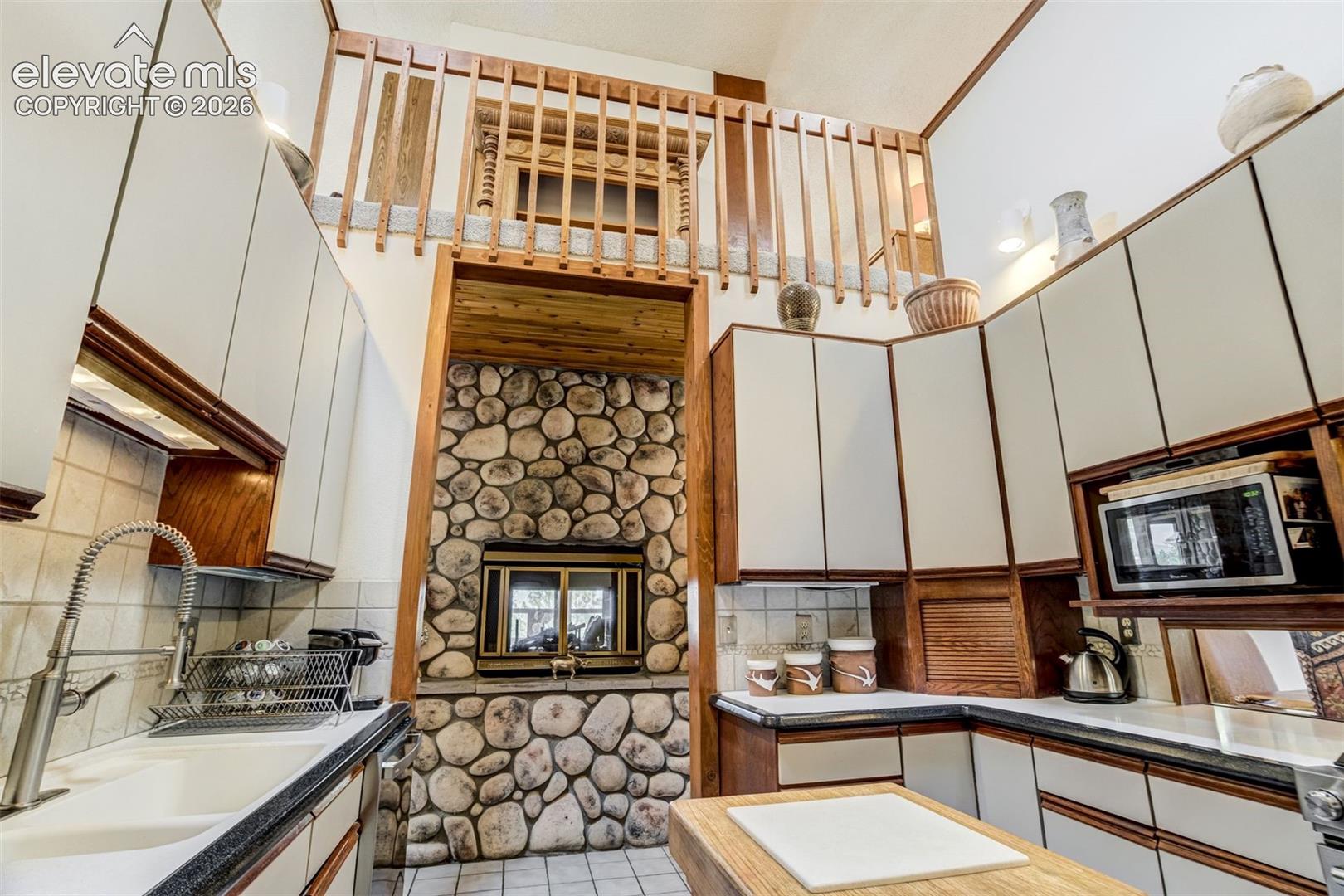 Kitchen boasts a lot of cabinet space, Subzero fridge, gas range, dishwasher an serving opening to the dining room