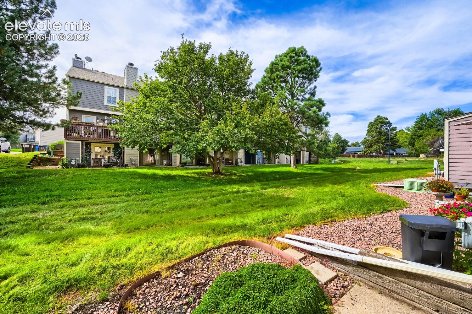 Expansive serene green space featuring mature trees and a gravel pathway
