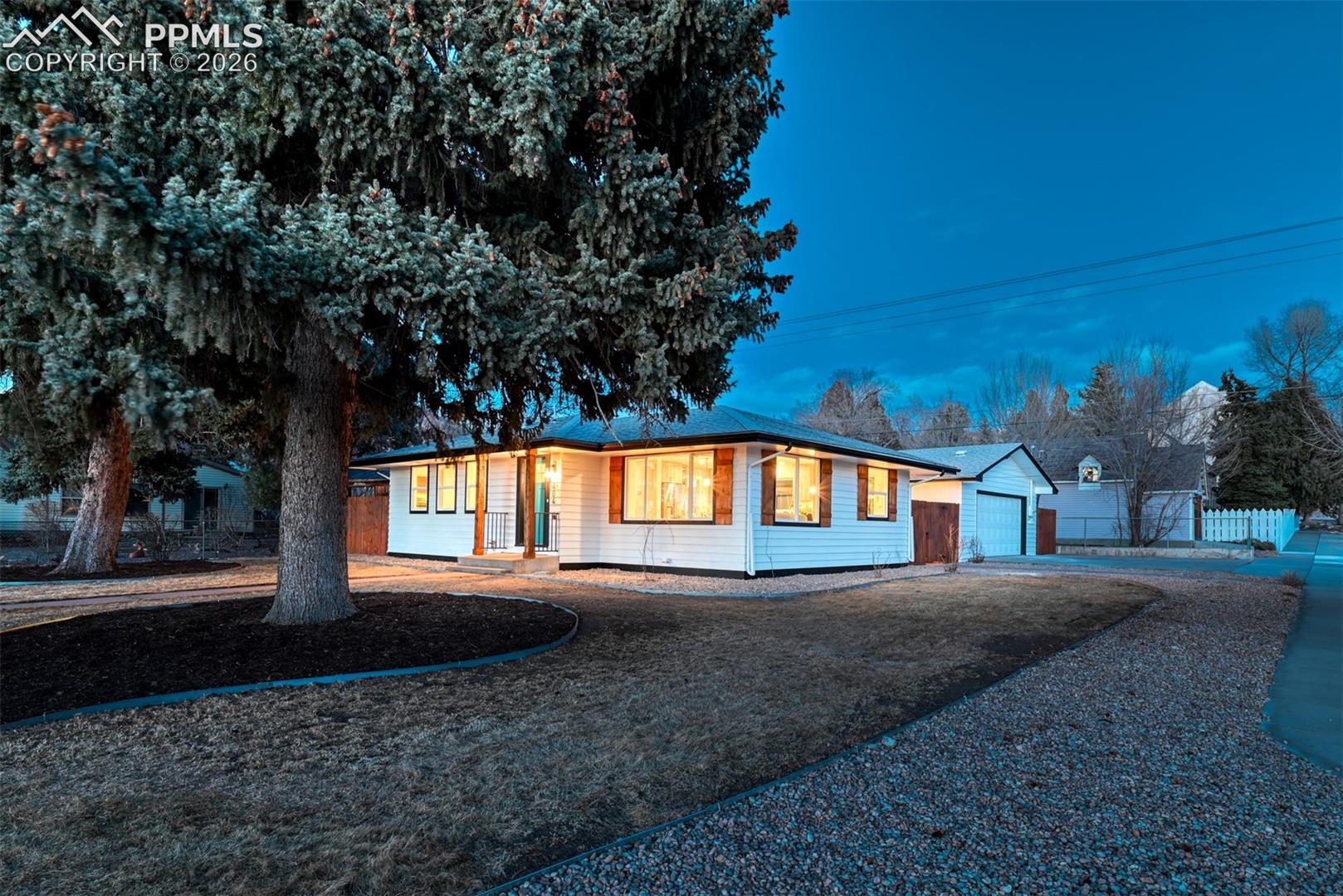 Ranch-style house with a garage, an outdoor structure, and driveway