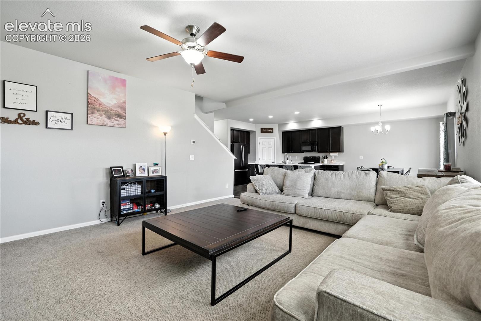 Open-concept living space with carpeted flooring, a ceiling fan with integrated lighting, and recessed lighting