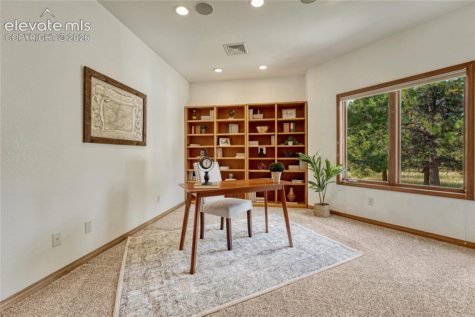 Main level office off the entry with included shelving.