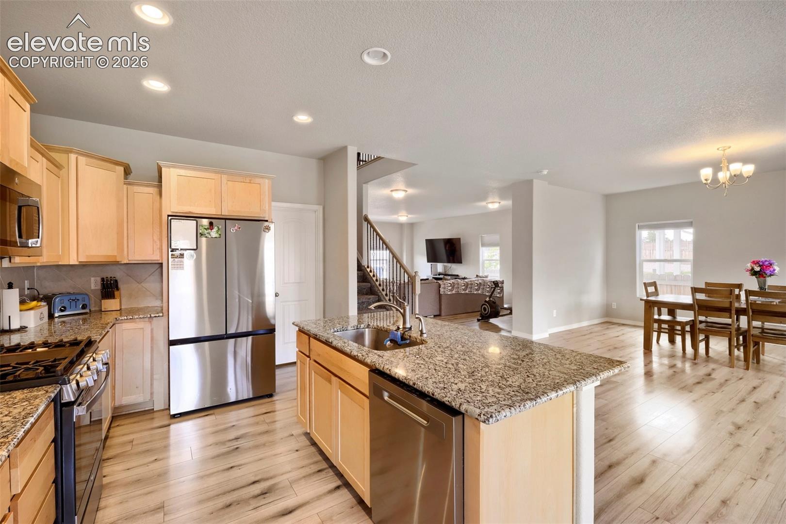 Kitchen featuring light wood cabinetry, granite countertops, and stainless steel appliances