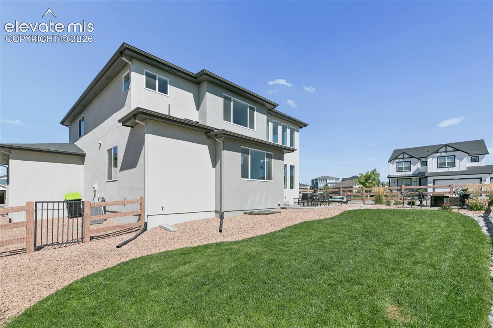 Expansive lawn with a gravel pathway, leading to a patio area