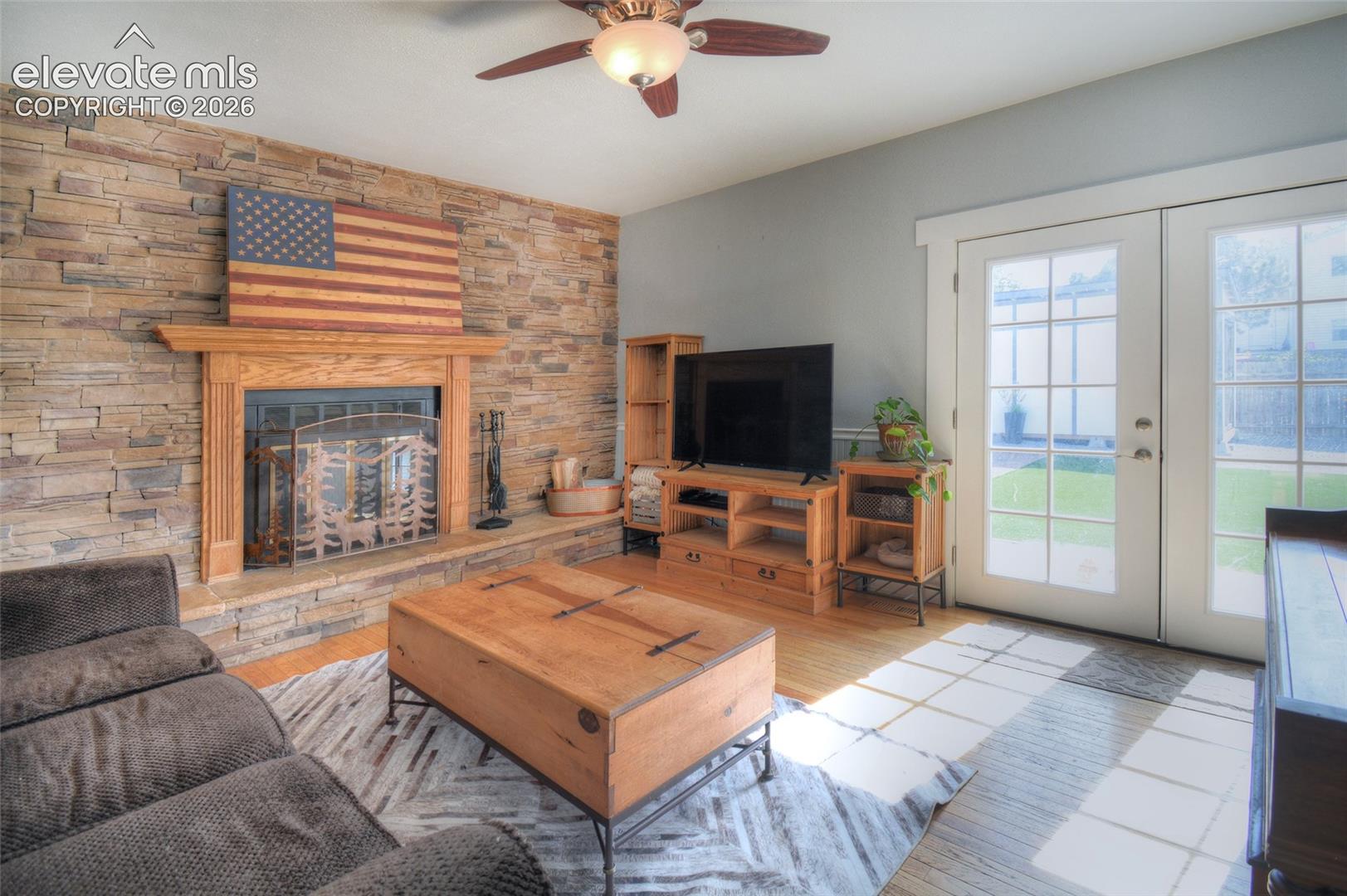 Wood burning fireplace with natural stone surround, wired for t.v. above fireplace, ceiling fan and french doors lead out to the backyard patio and fully landscaped backyard! 