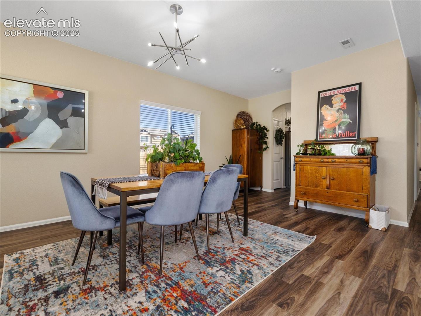 LVP Wood-look flooring throughout, complemented by a modern chandelier fixture