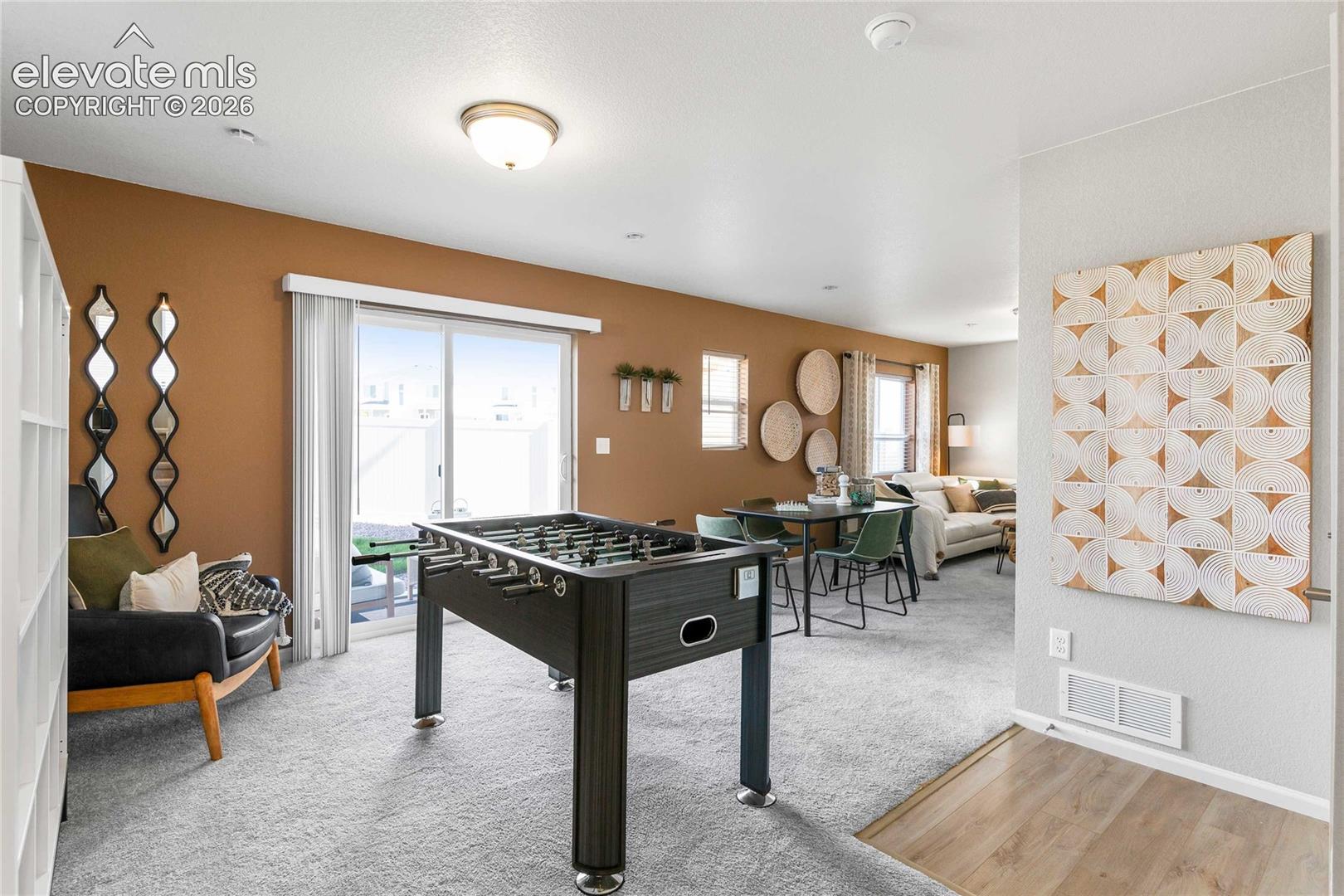 Sliding glass door, light wood-finish flooring, recessed lighting, neutral carpeting, and a built-in shelving unit
*photos of a model home*