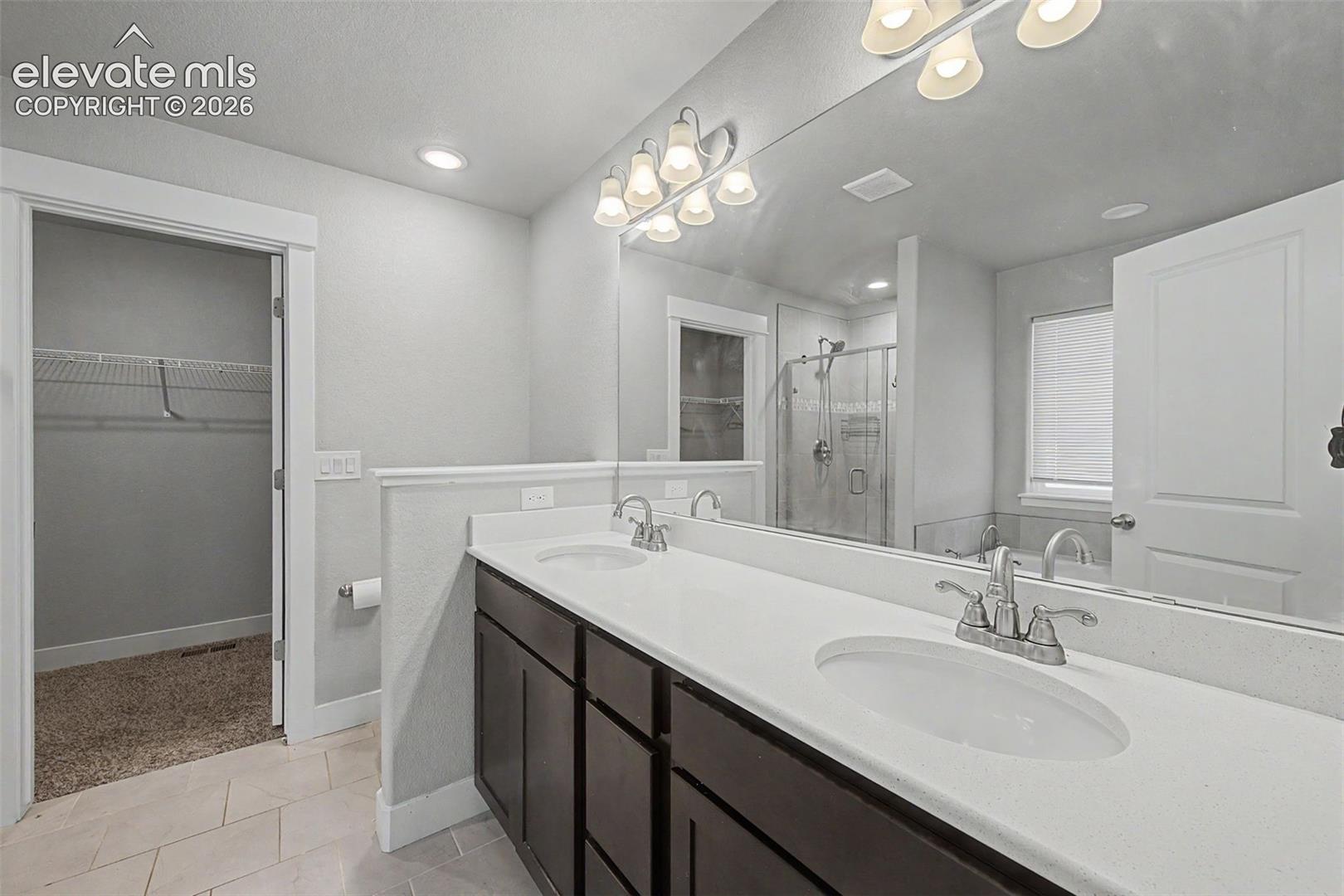 Dual vanity with white countertops and dark wood cabinetry