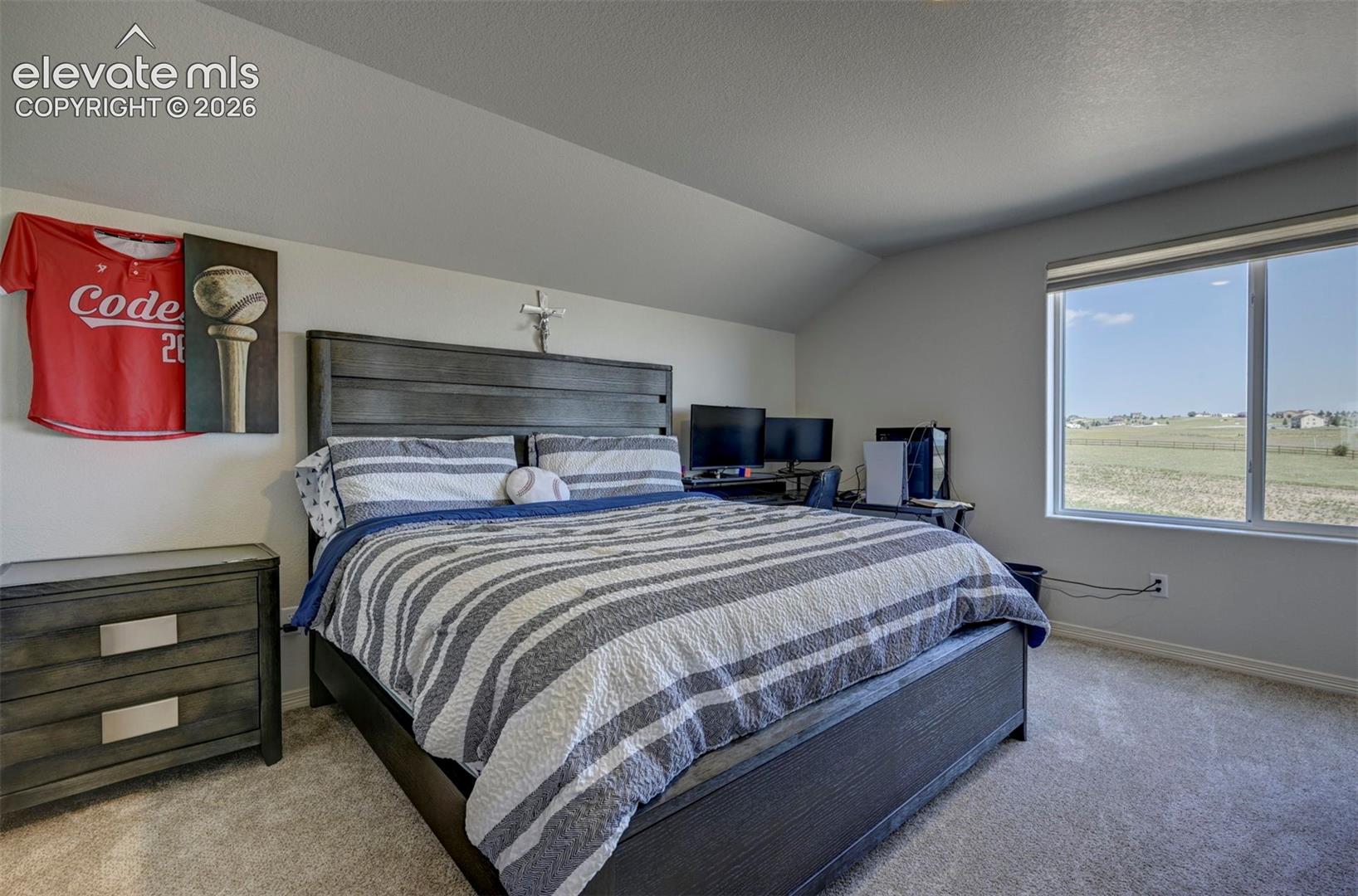 Carpeted room with a large window, providing natural light