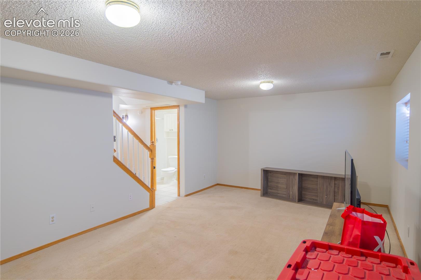 A second living area with neutral finishes and recessed lighting, ready to suit your needs.