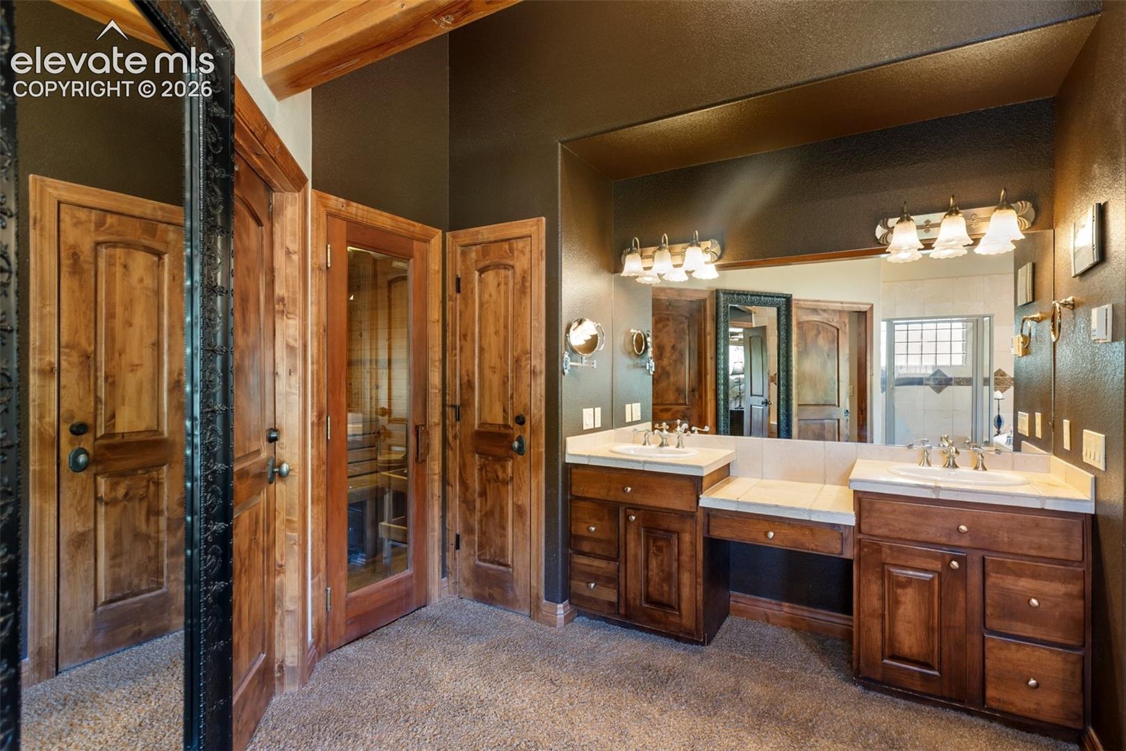 Glass door entry to the dry sauna located in the primary bathroom.