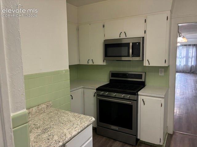 Kitchen featuring white cabinetry with dark hardware, a stainless steel range, and a coordinating stainless steel over-the-range microwave