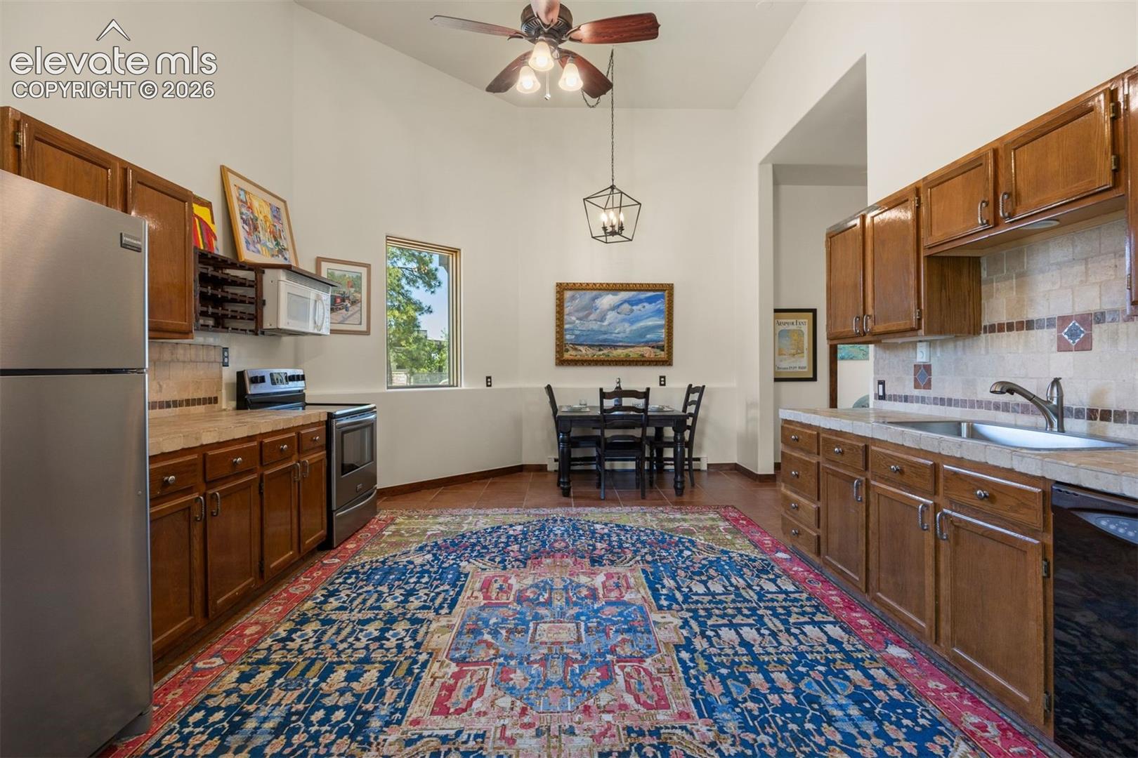 Casita's spacious kitchen with electric range, dishwasher, microwave, and refrigerator, with ample counter space, warm wood cabinetry, and an eat-in dining area. 
