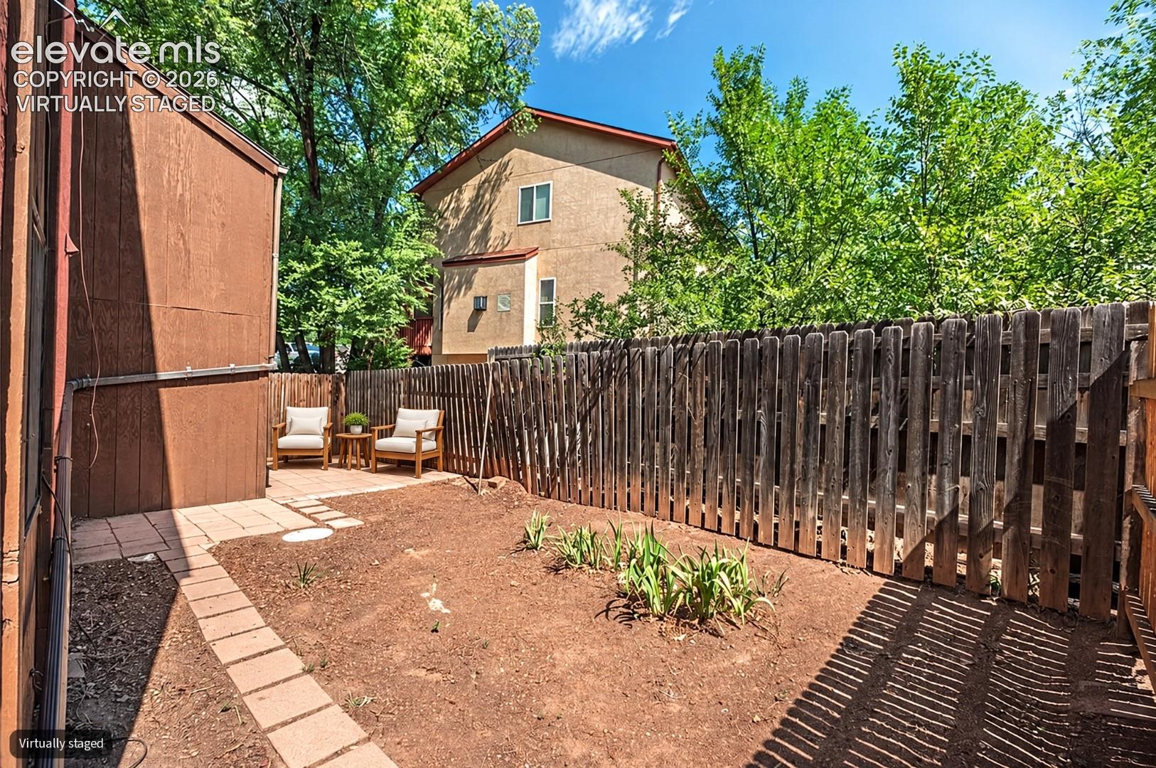 Virtually Staged Paved patio area, wood fencing, and established ground cover