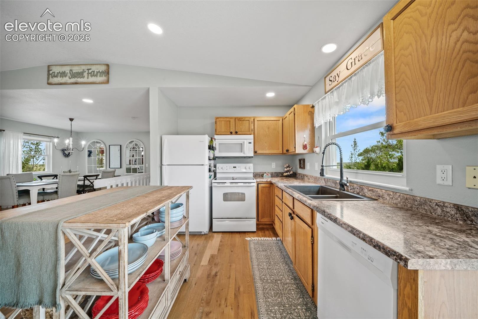 Kitchen featuring wood-finish flooring, recessed lighting, wood cabinetry, and a double basin sink with a gooseneck faucet