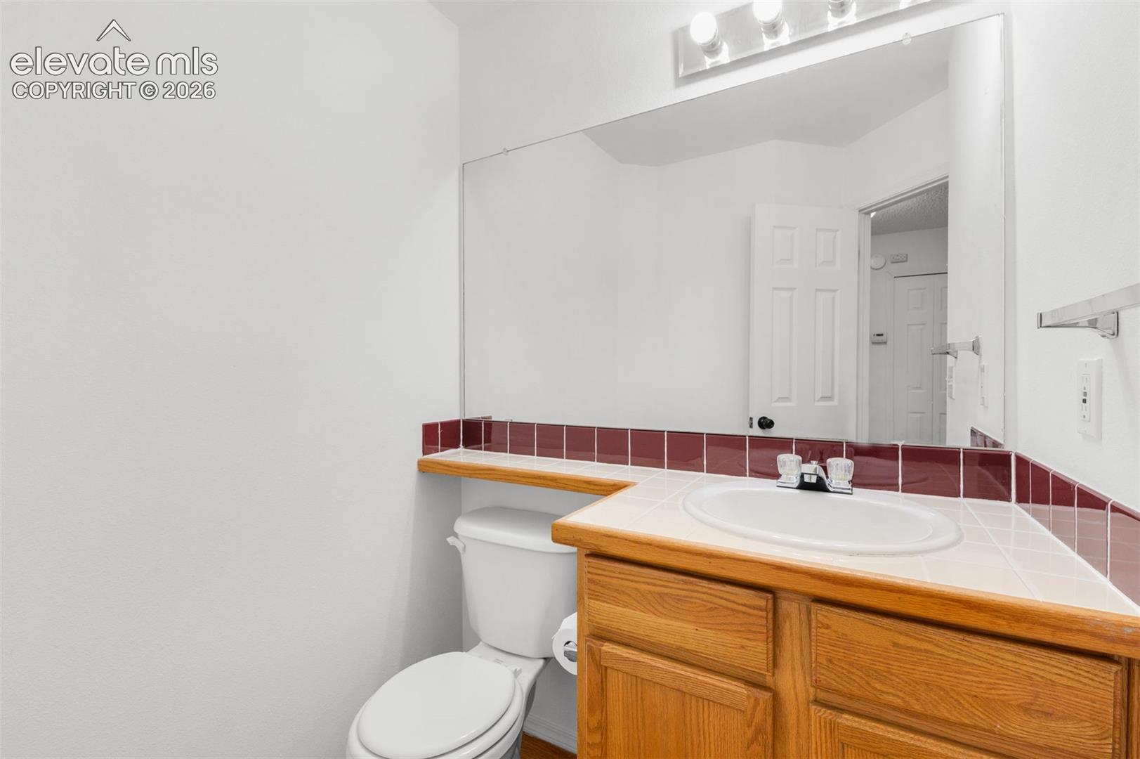Wood-finish vanity with an integrated sink and tiled countertop