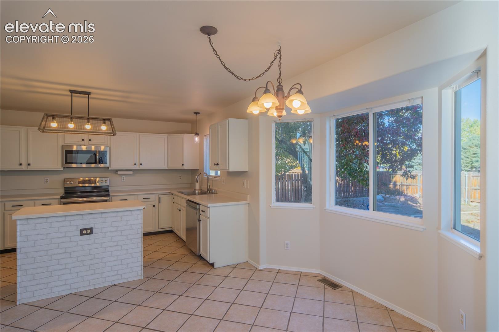 A sunlit dining nook with bay-style windows overlooks the backyard.