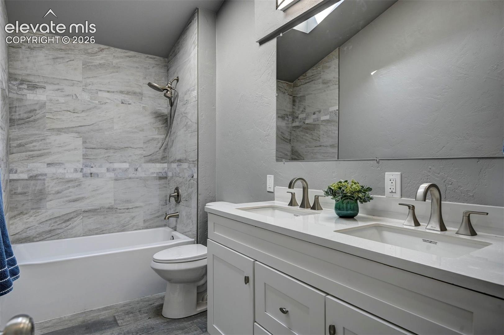 Double vanity featuring white cabinetry, a light-toned solid surface countertop, and dual undermount sinks with brushed nickel faucets