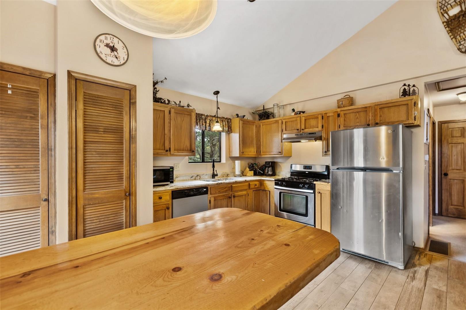 Kitchen featuring light wood cabinetry, stainless steel appliances, and a wood-finish countertop