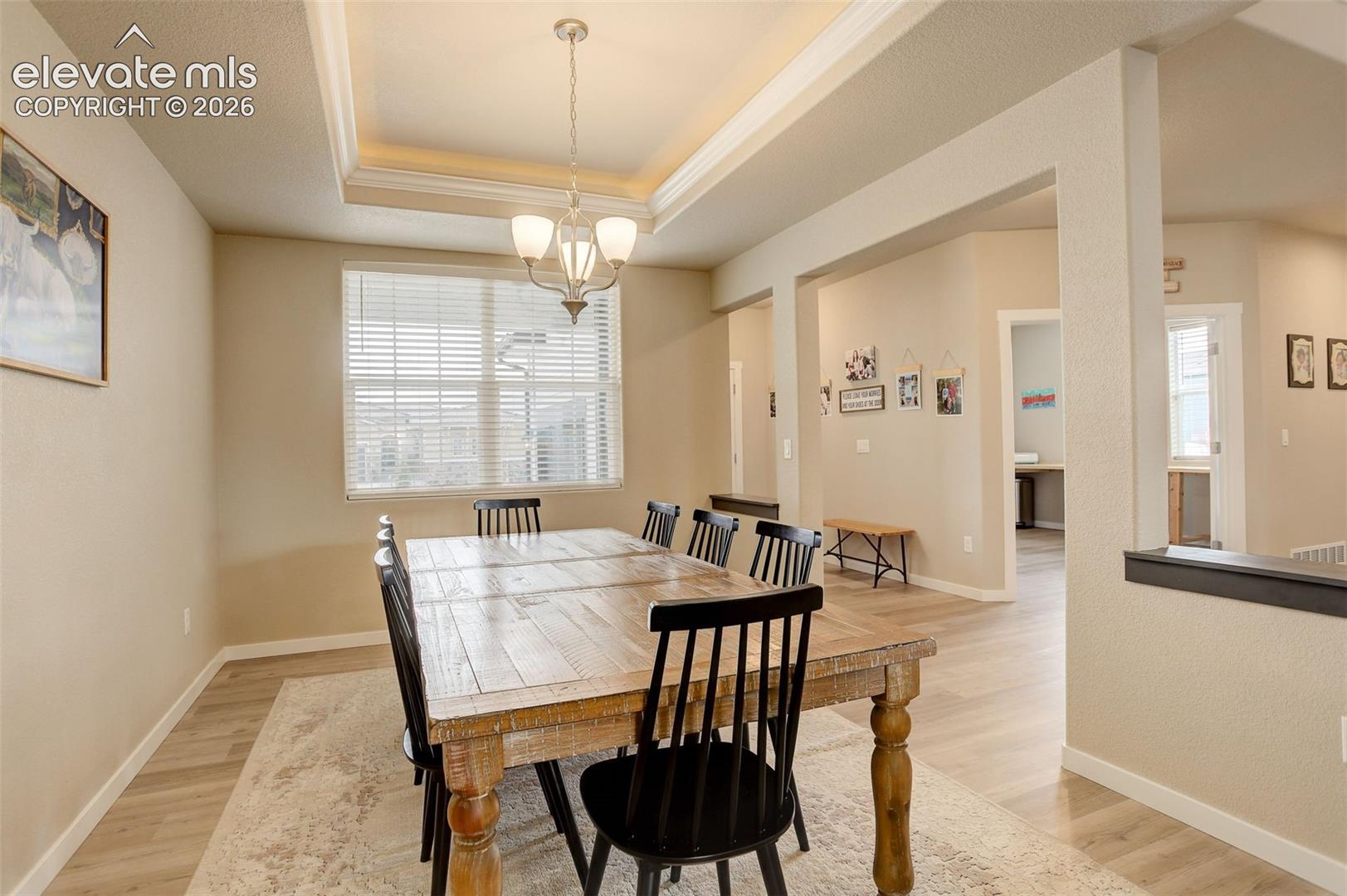 Living area, white oak LVP, recessed lighting, and oversized windows.