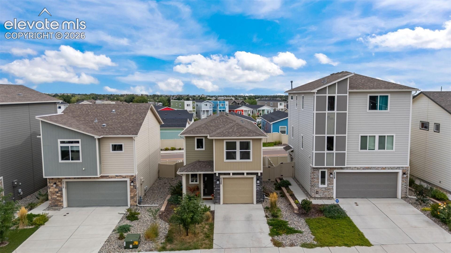 Modern architectural design featuring varied siding materials, attached garages, and paved driveways