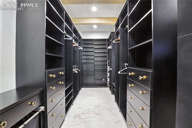 Walk in closet with light marble finish floors