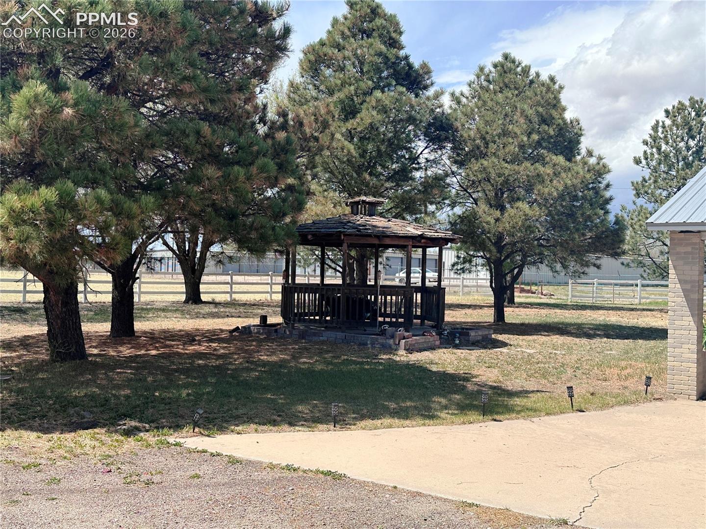 Gazebo shown nestled in the trees .