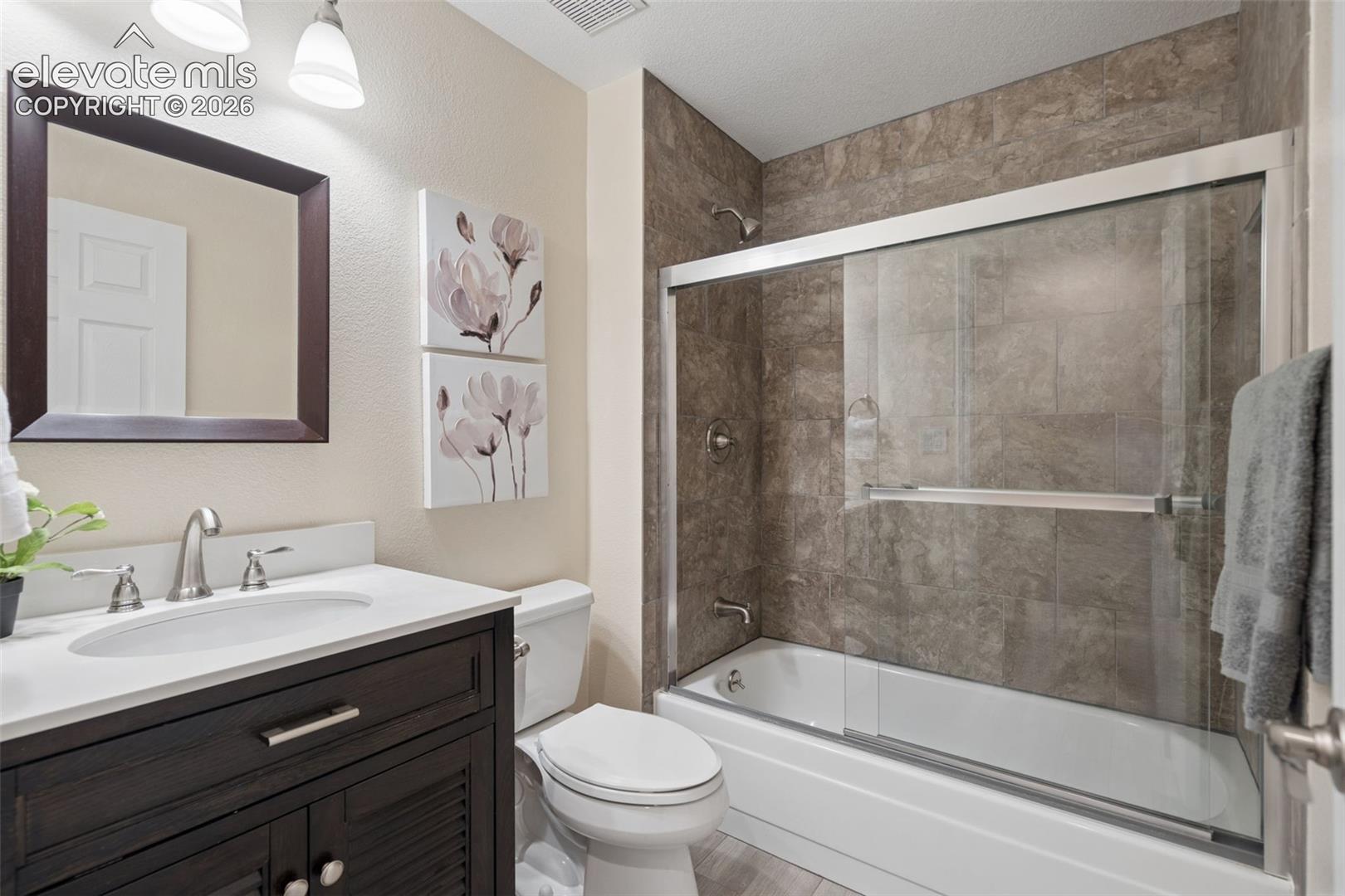 Full Bathroom #1 on main floor w/wide tile flooring & glass doors