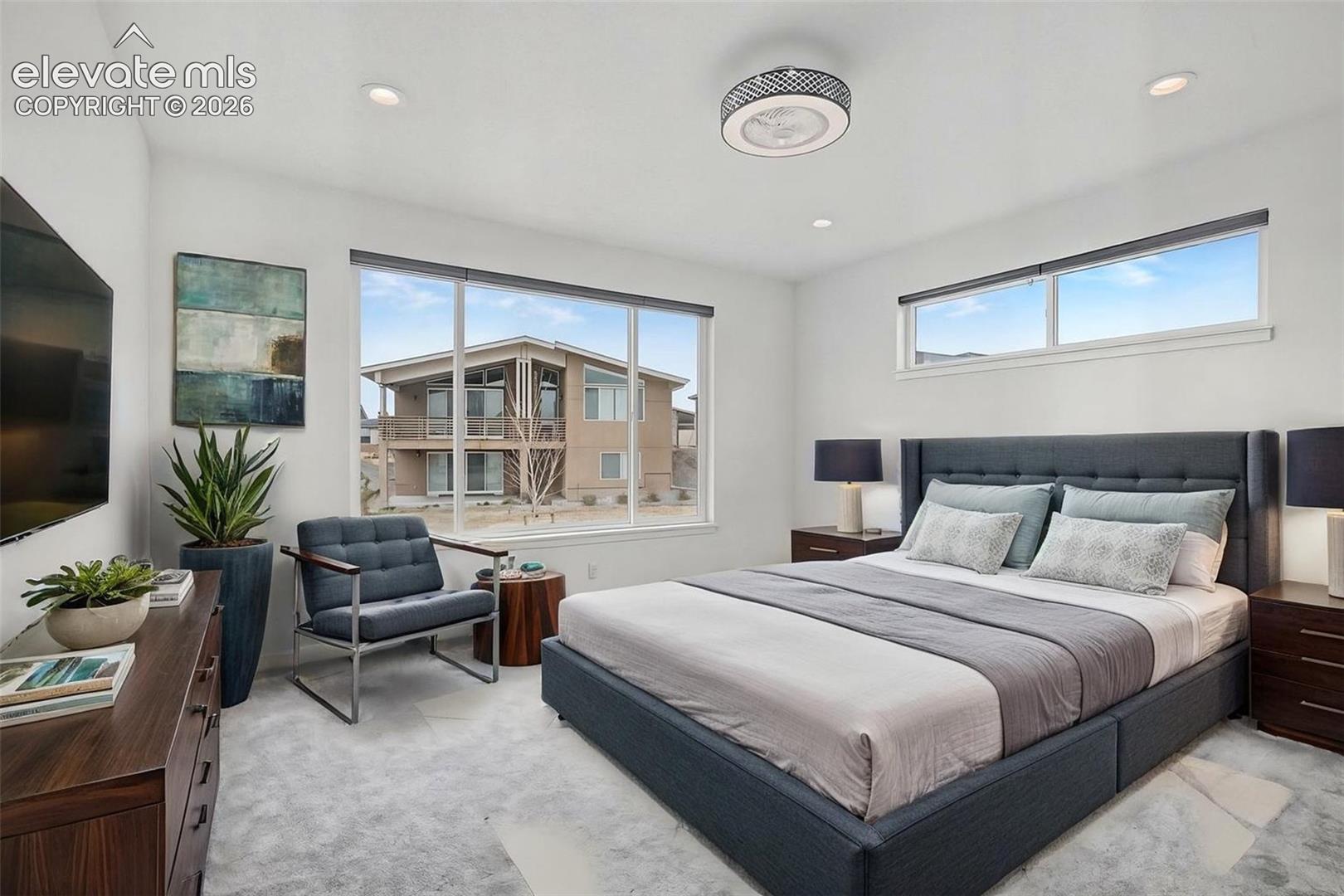 Recessed lighting, large picture windows, wood-finish dresser, and contemporary ceiling fan