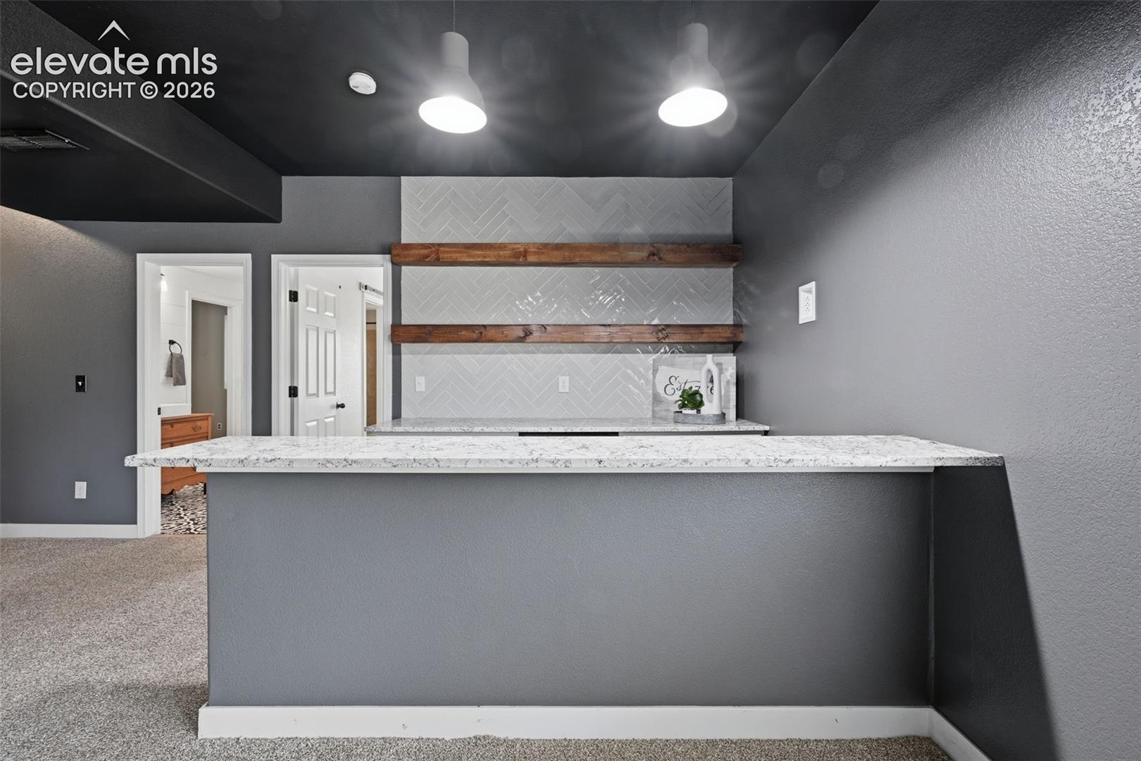 Basement wet bar with upgraded counters, open shelving and wine cooler!