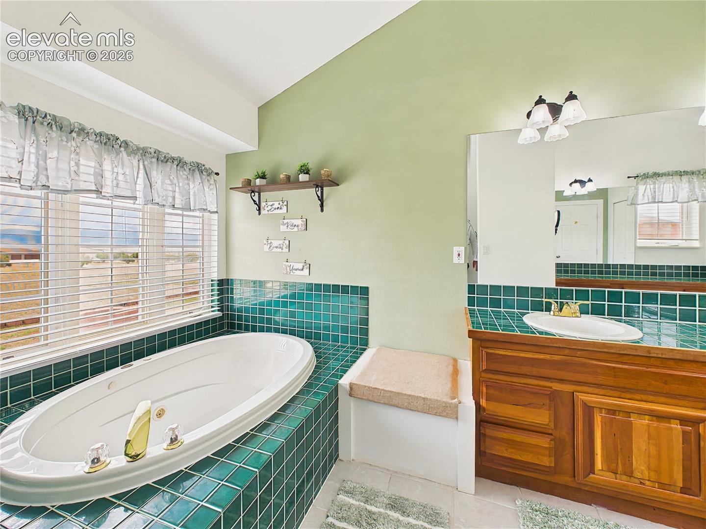 Bright and inviting retreat featuring custom tilework, abundant natural light, and serene views from the soaking tub.