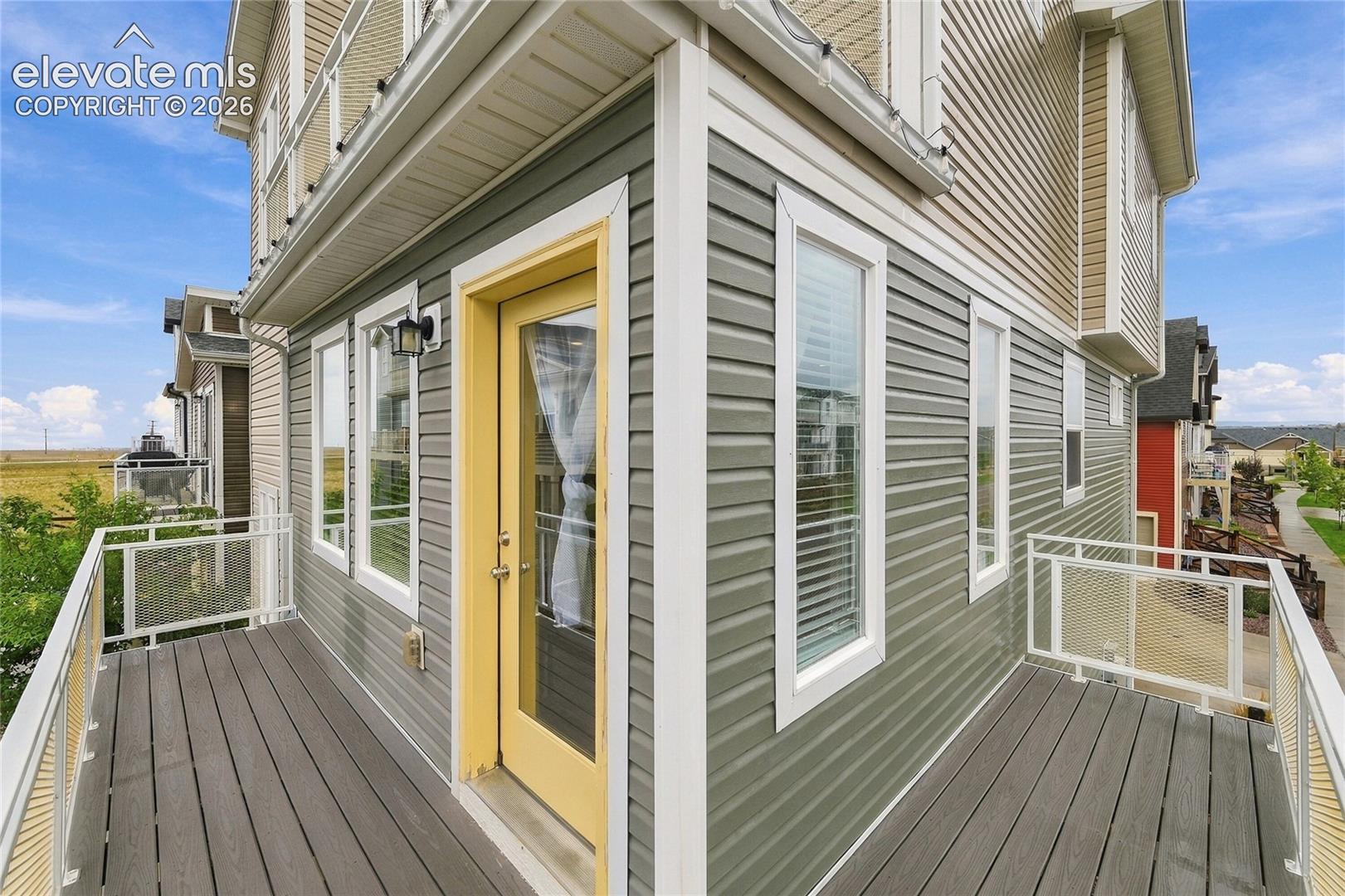 Outdoor balcony with composite decking, white aluminum railings, and clear glass panels