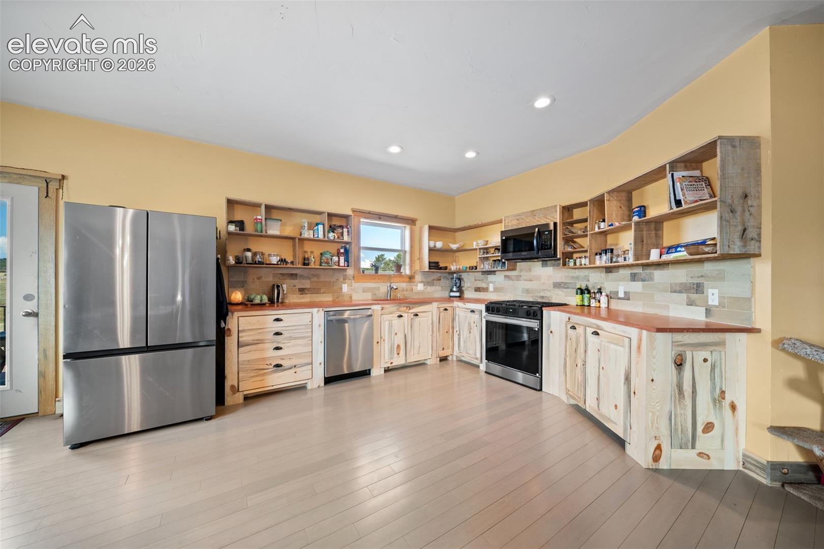 Custom Bettkill pine cabinetry and fossil tile accents.