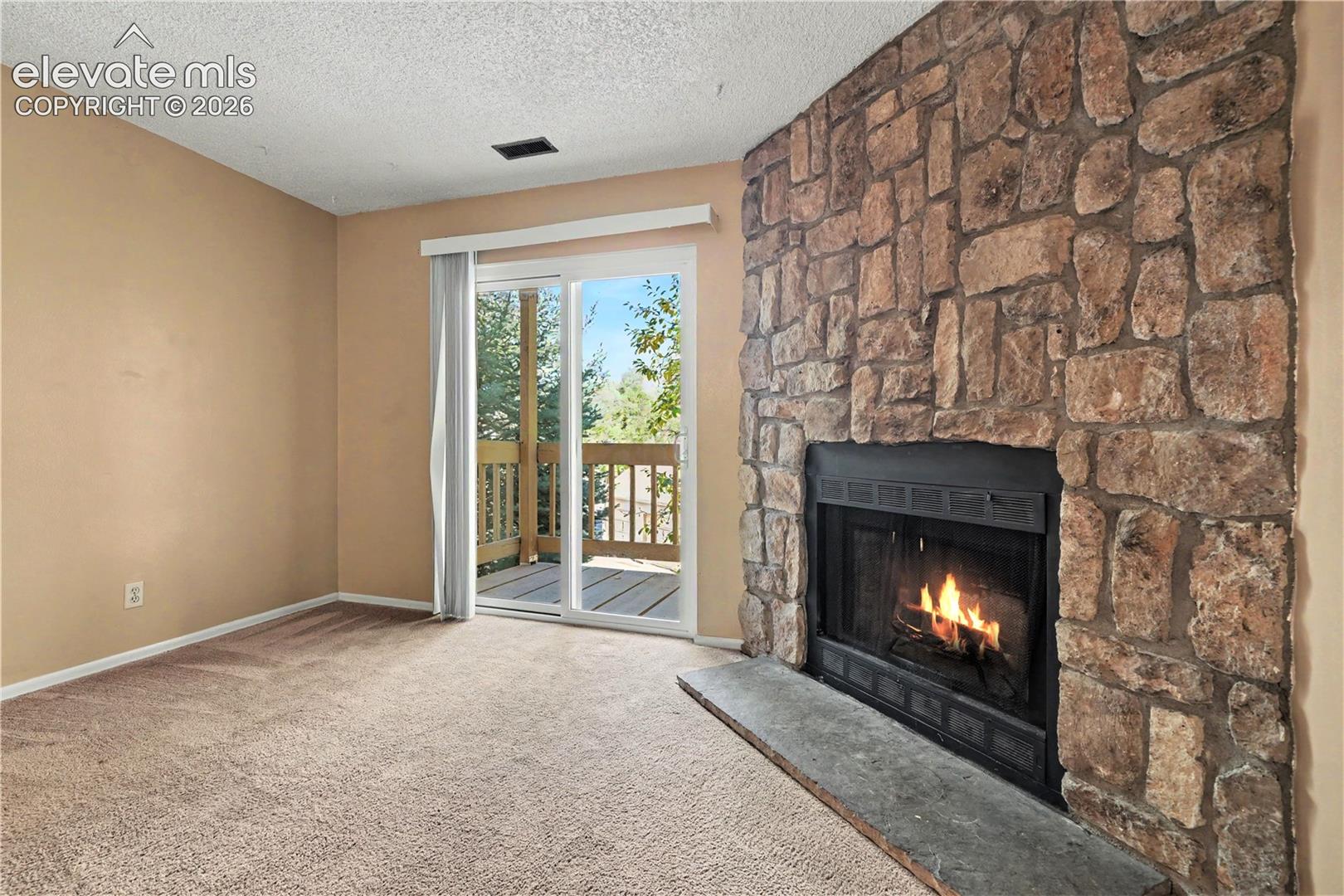 Living room with fireplace and patio access