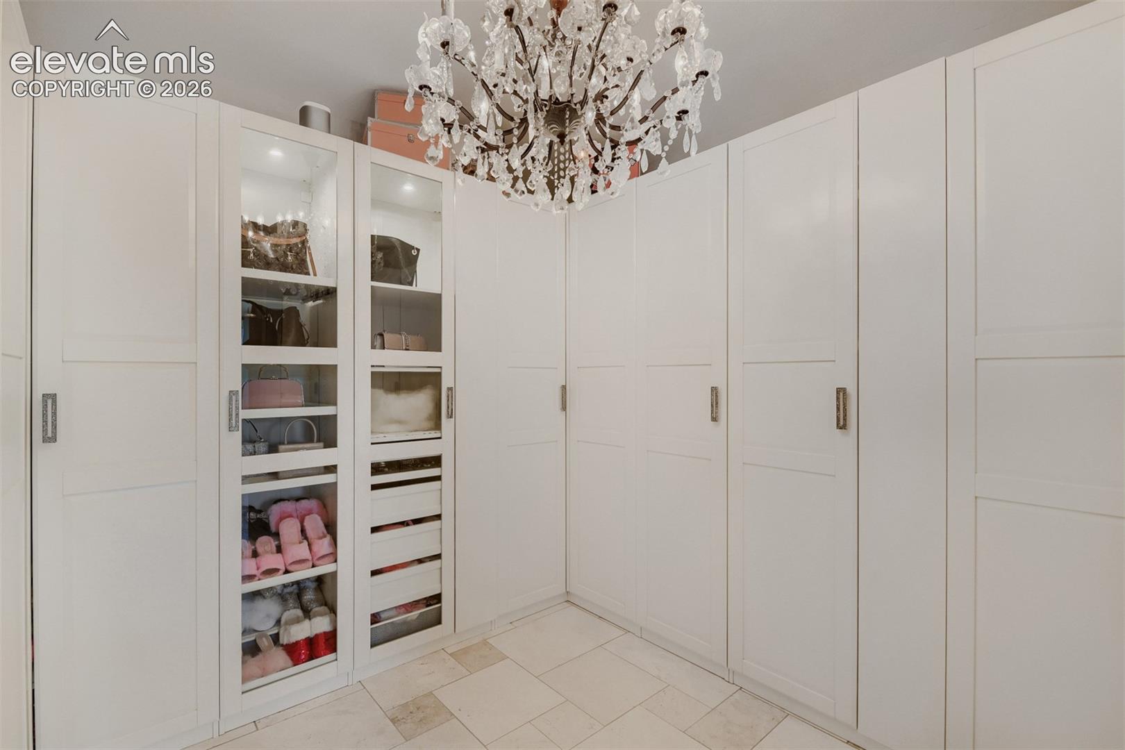 Custom cabinetry, enclosed hanging clothes with an excellent display case