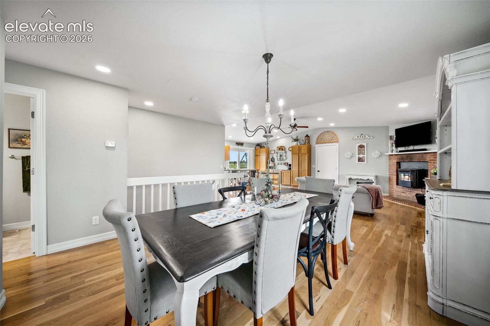 Dining area with wood-finish flooring, recessed lighting, and a chandelier