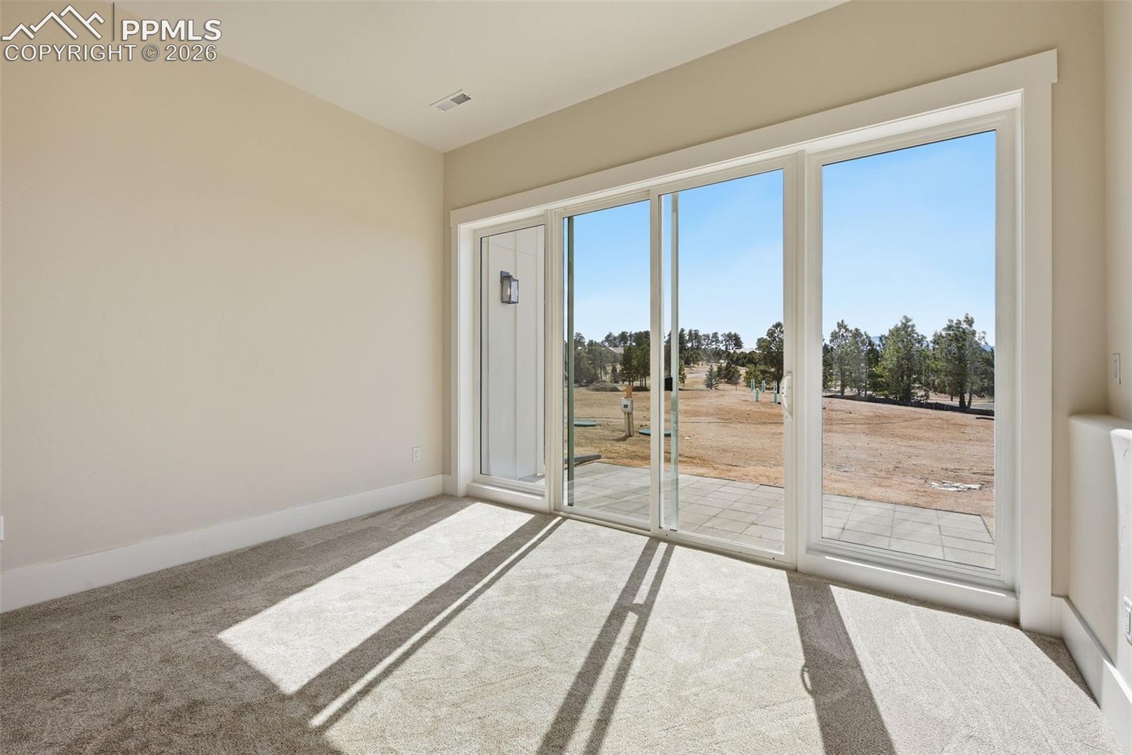 Spare room featuring light carpet and baseboards