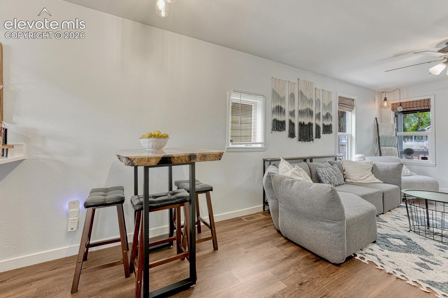 Open-concept living area featuring white walls, and multiple windows with blinds