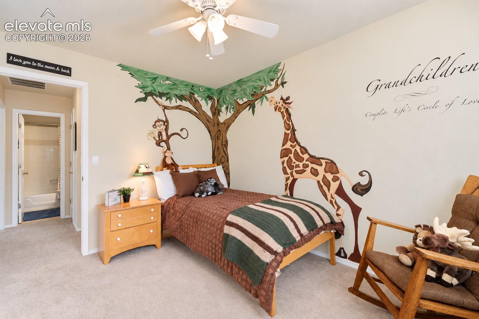 Upper Level Bedroom with a whimsical hand-painted mural, soft carpeting, walk in closet, and convenient hallway access to a private bath. 